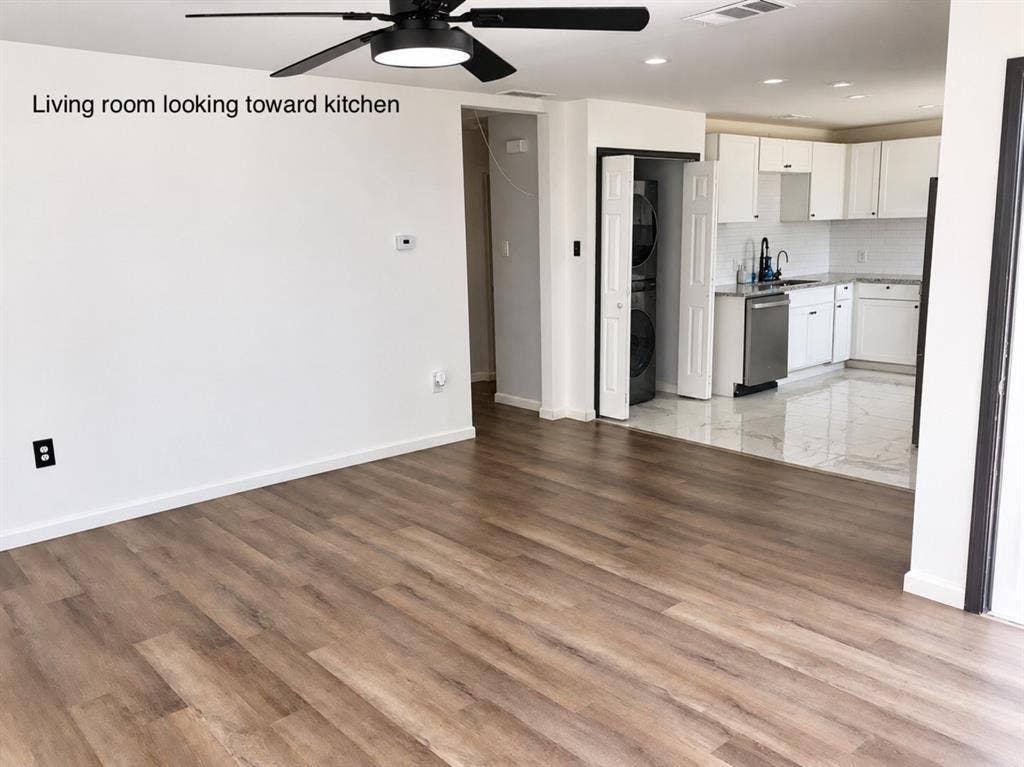 709 SW Dallas Street, Grand Prairie, TX 75051 Wood-finish flooring, matte black ceiling fan with integrated lighting, recessed ceiling lights, white cabinetry, and polished stone-finish floor tiling