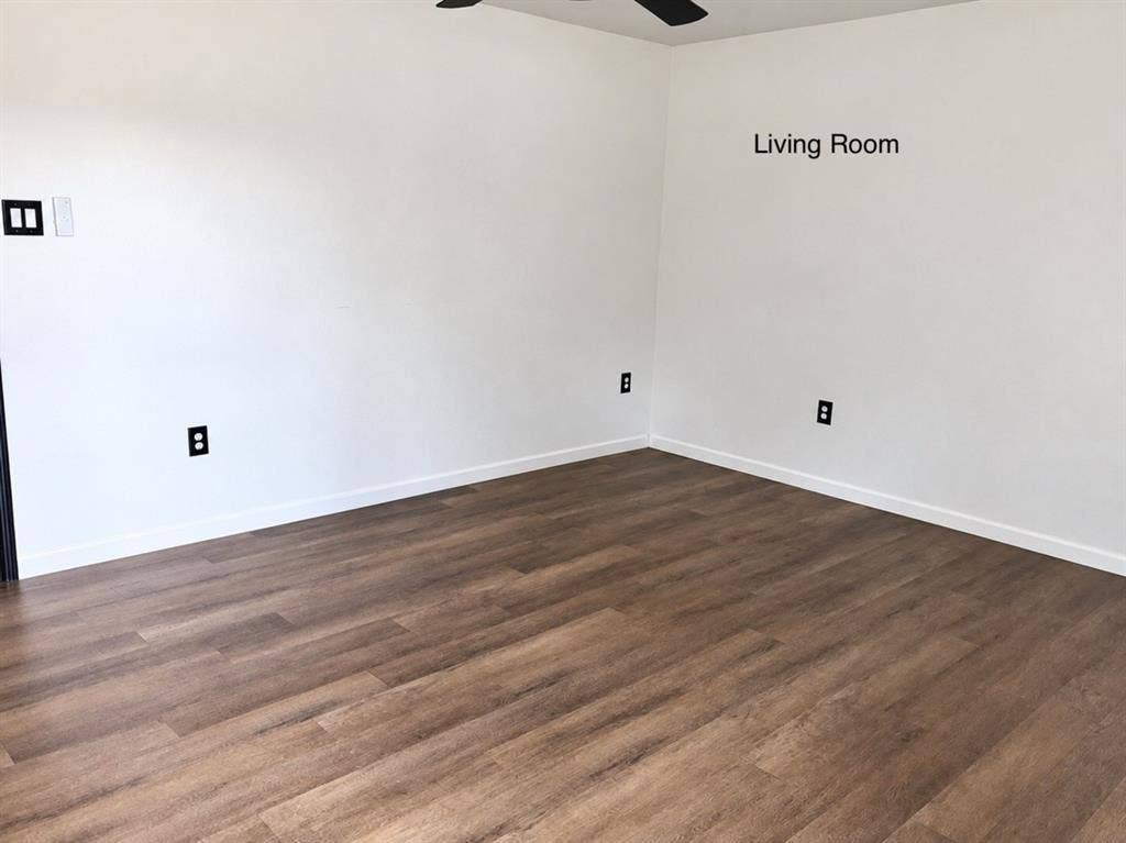709 SW Dallas Street, Grand Prairie, TX 75051 Neutral-toned walls and wood-finish flooring featuring a ceiling-mounted light fixture