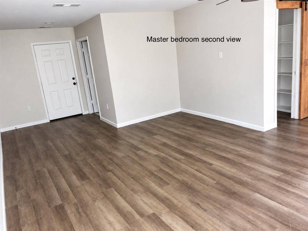 709 SW Dallas Street, Grand Prairie, TX 75051 Wood-finish flooring, neutral wall tones, recessed lighting, and built-in shelving unit featuring a sliding wood-finish barn door