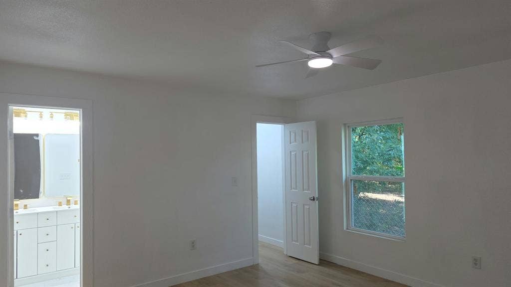 3426 Edgewood Street, Dallas, TX 75215 Room featuring a ceiling fan with integrated lighting, wood-finish flooring, and white six-panel interior doors