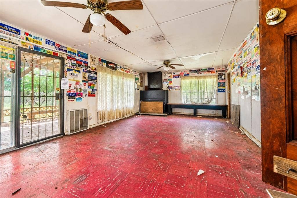 Multi-purpose room featuring tile flooring, dual ceiling fans, and a sliding glass door with security screen