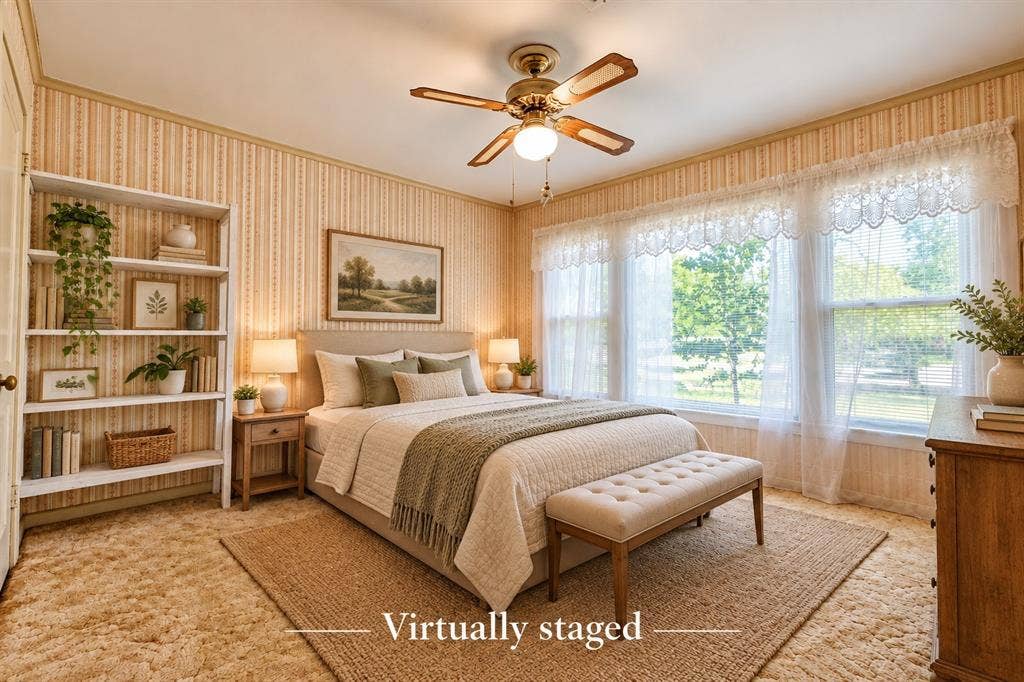 Bedroom featuring integrated wall shelving, patterned wall covering, a brass-tone ceiling fan with central lighting, and a multi-pane window configuration
