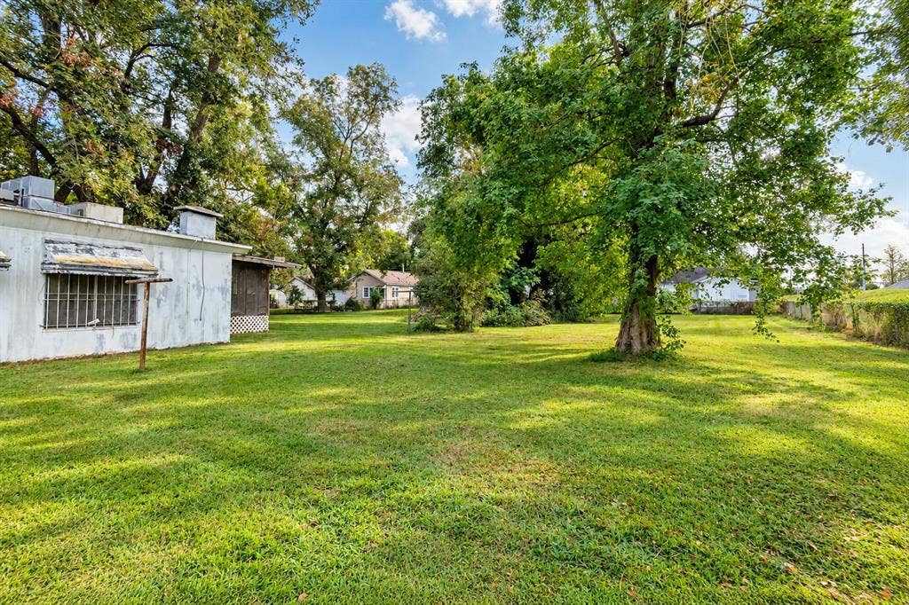 Expansive rear grounds featuring mature trees and established lawn