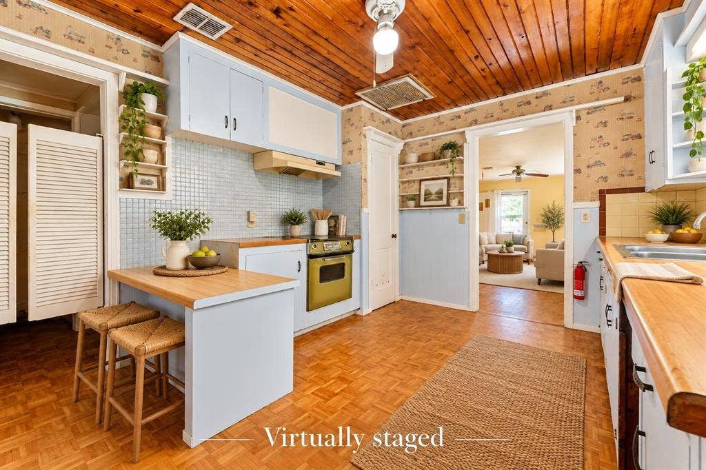 Kitchen featuring wood-plank ceiling, parquet flooring, wood-surface countertops, blue cabinetry, and tiled backsplash