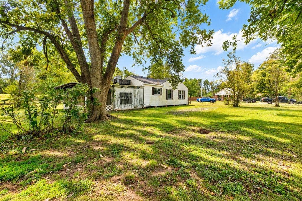 Expansive lot featuring mature shade trees, a screened-in porch, and a detached structure