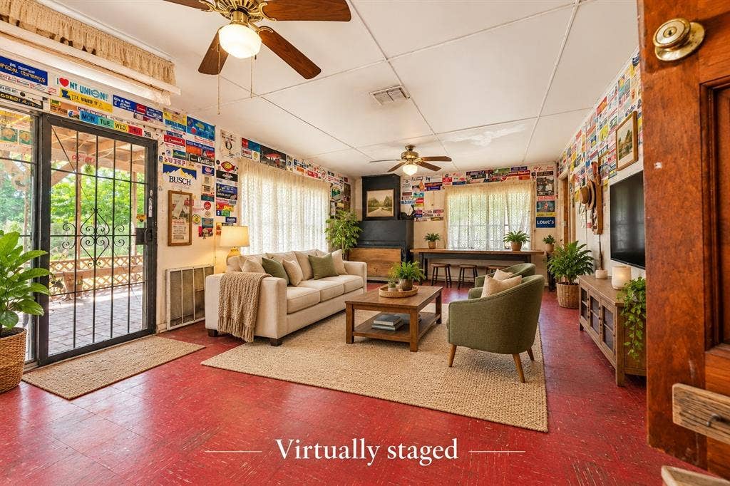 Living area featuring dual ceiling fans, ample natural light through expansive windows, and a sliding glass door with a metal security screen