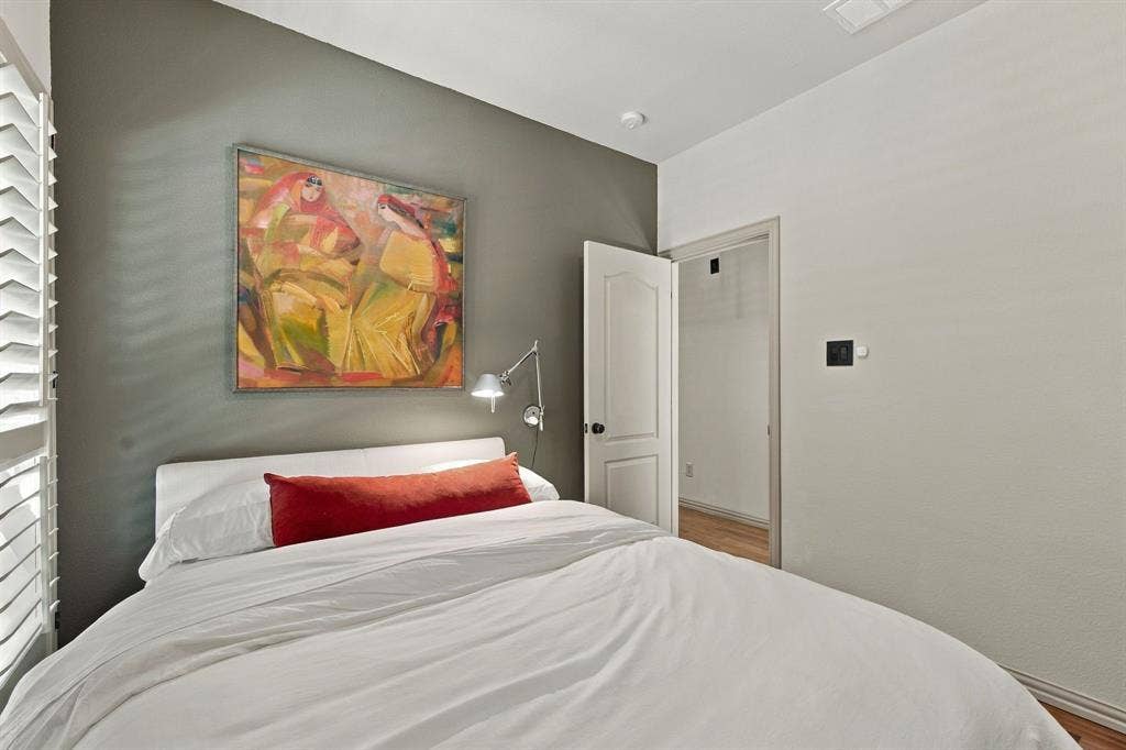 Accent wall in a neutral tone, wall-mounted adjustable metal light fixture, and classic two-panel interior door