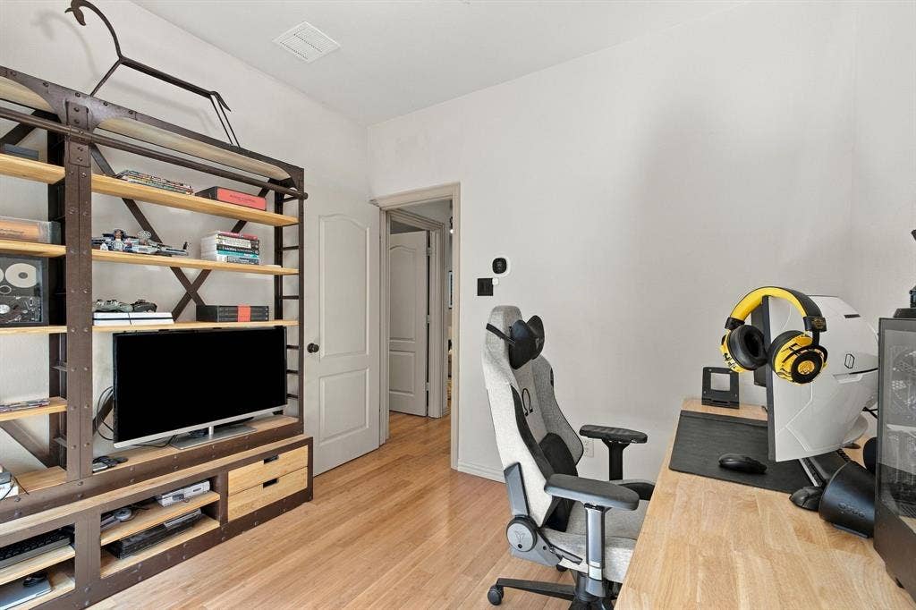 Room with wood-finish flooring and an arched-top panel door