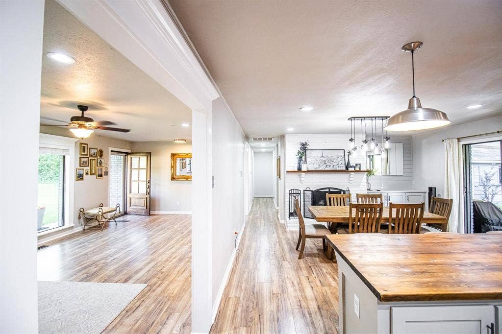 1040 Wedgewood Drive, Woodway, TX 76712 Wood-finish flooring, recessed lighting, wood-topped kitchen island, painted brick fireplace, and pendant light fixtures