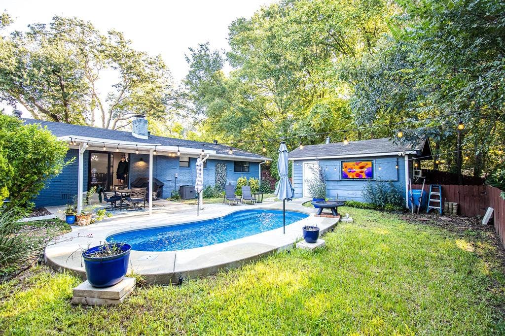 1040 Wedgewood Drive, Woodway, TX 76712 Expansive backyard featuring an in-ground pool with concrete decking, covered patio, detached structure, and mature tree canopy
