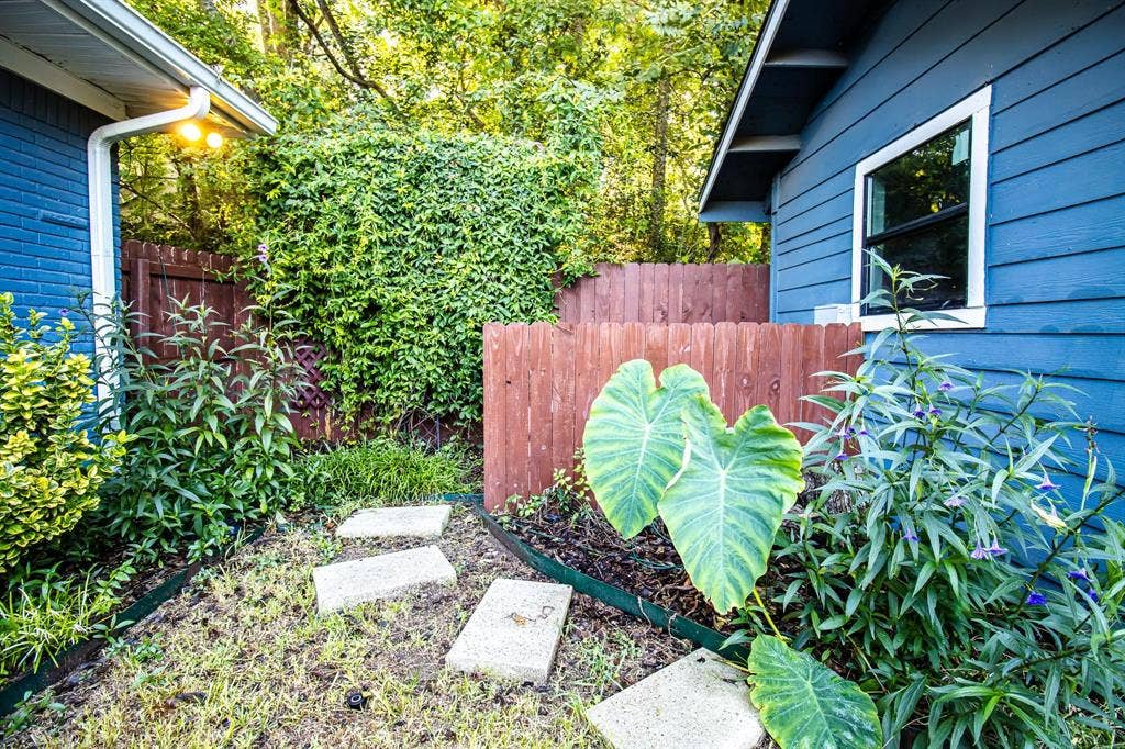 1040 Wedgewood Drive, Woodway, TX 76712 Exterior space featuring horizontal lap siding, wood privacy fencing, a concrete paver walkway, and established landscaping