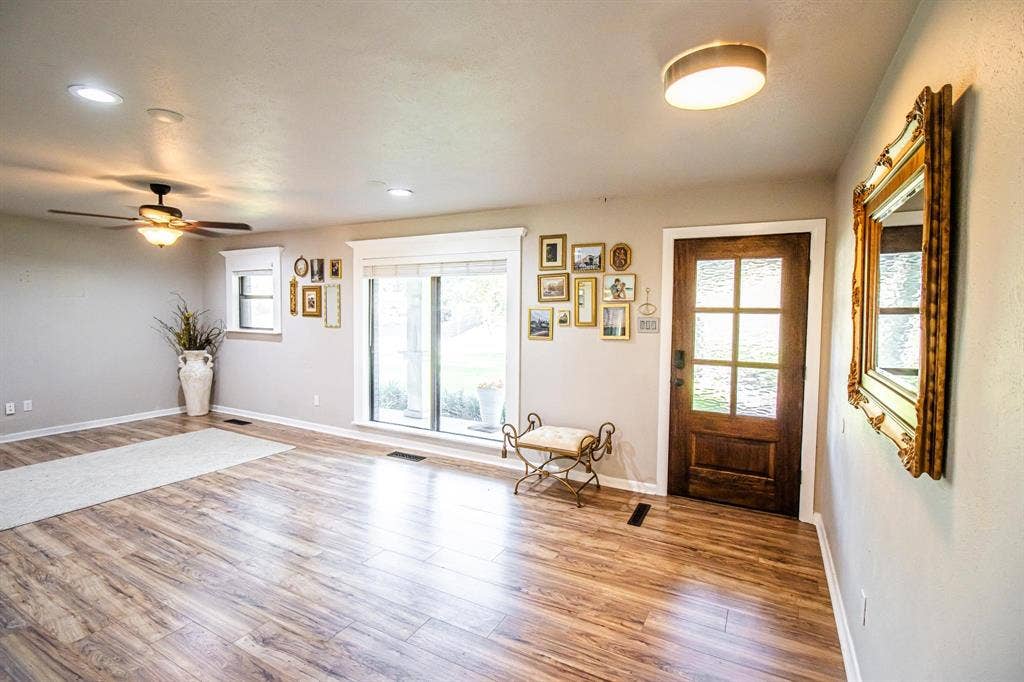 1040 Wedgewood Drive, Woodway, TX 76712 Wood-finish flooring, six-panel glass front door, recessed lighting, ceiling fan with light kit, and large windows with thick-profile trim