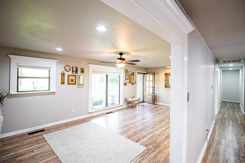 1040 Wedgewood Drive, Woodway, TX 76712 Open floor plan featuring wood-finish flooring, recessed lighting, ceiling fan, and window trim with wide molding