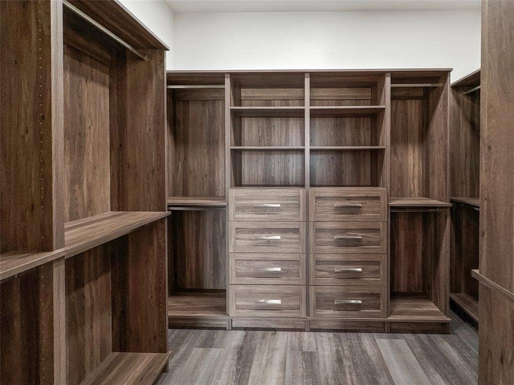 Spacious closet featuring dark hardwood / wood-style flooring