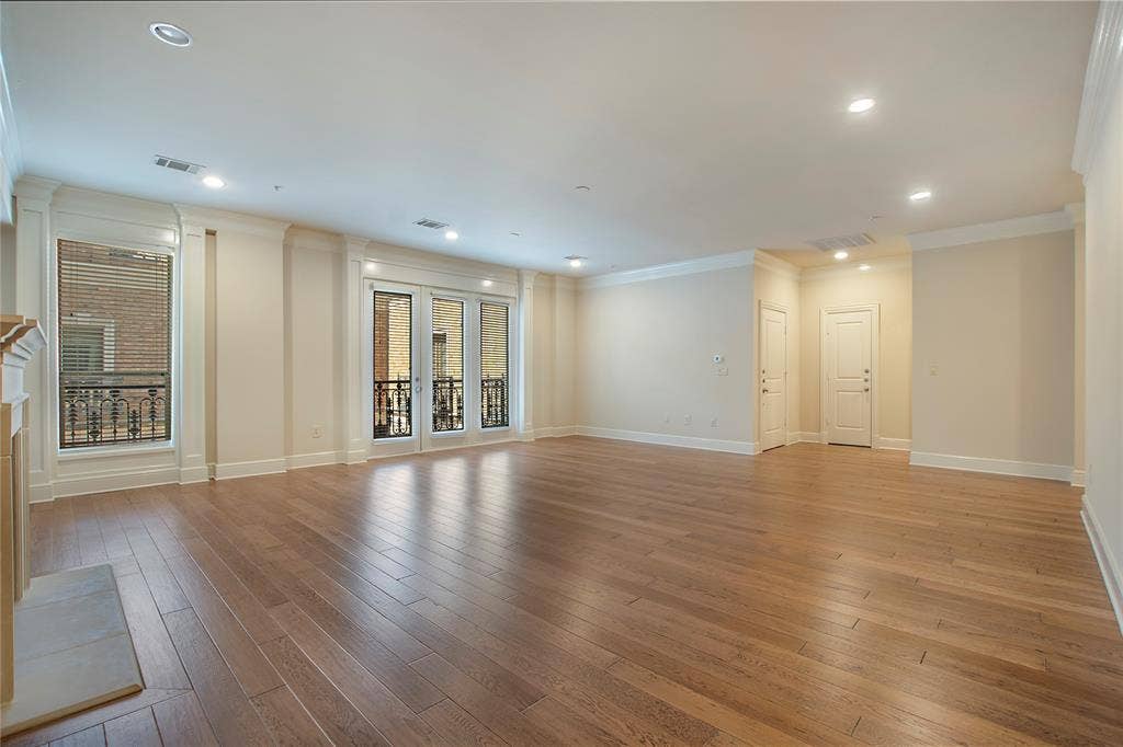 Unfurnished living room featuring ornamental molding and light wood-type flooring