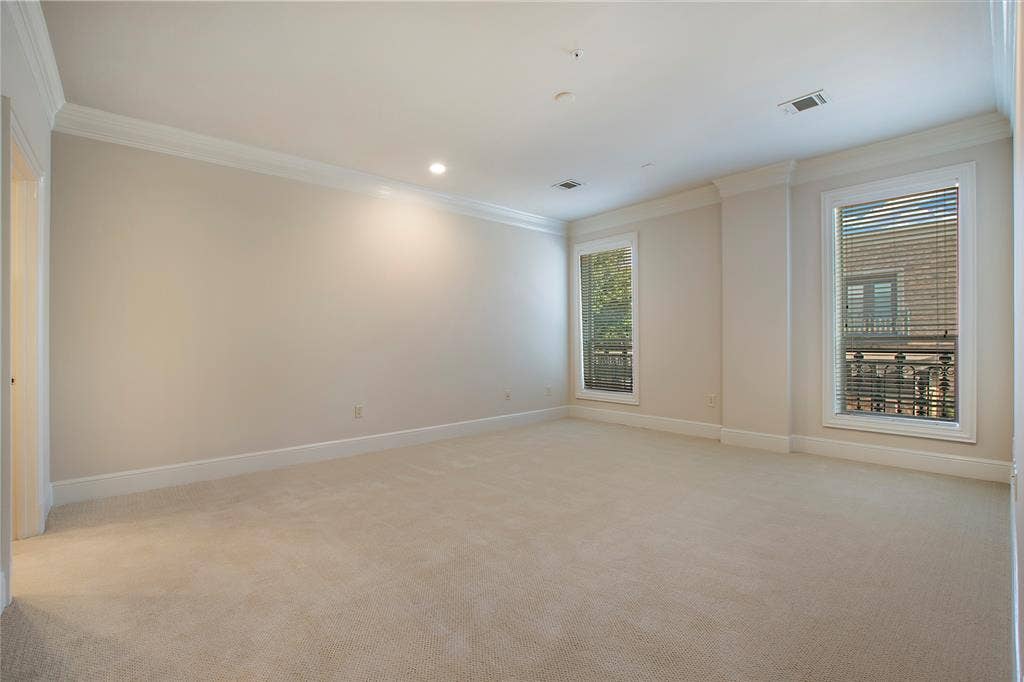 Unfurnished room with a wealth of natural light, crown molding, and light carpet