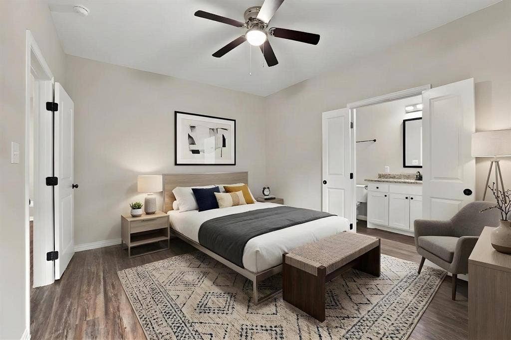 1116 S 6th Avenue, Denison, TX 75021 Neutral-toned bedroom featuring wood-finish flooring, a ceiling fan with integrated lighting, and double-door entry to the bathroom