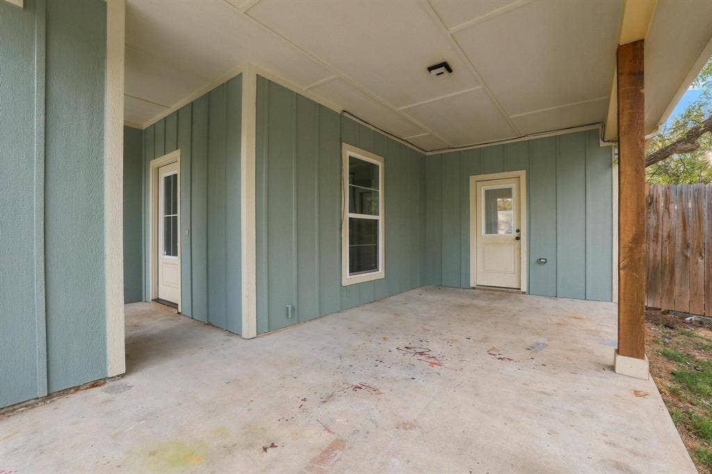 1116 S 6th Avenue, Denison, TX 75021 Covered patio featuring vertical board-and-batten siding, concrete flooring, and a structural timber support post
