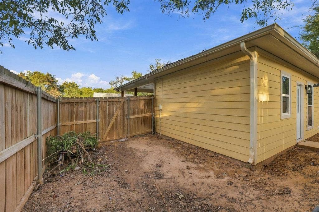 1116 S 6th Avenue, Denison, TX 75021 Exterior horizontal siding, wood privacy fencing, and gated access