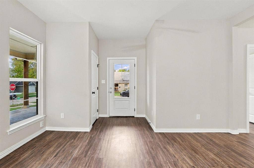 1116 S 6th Avenue, Denison, TX 75021 Entryway featuring wood-finish flooring, a neutral color palette, a glass-panel entry door, and a tall window with natural light