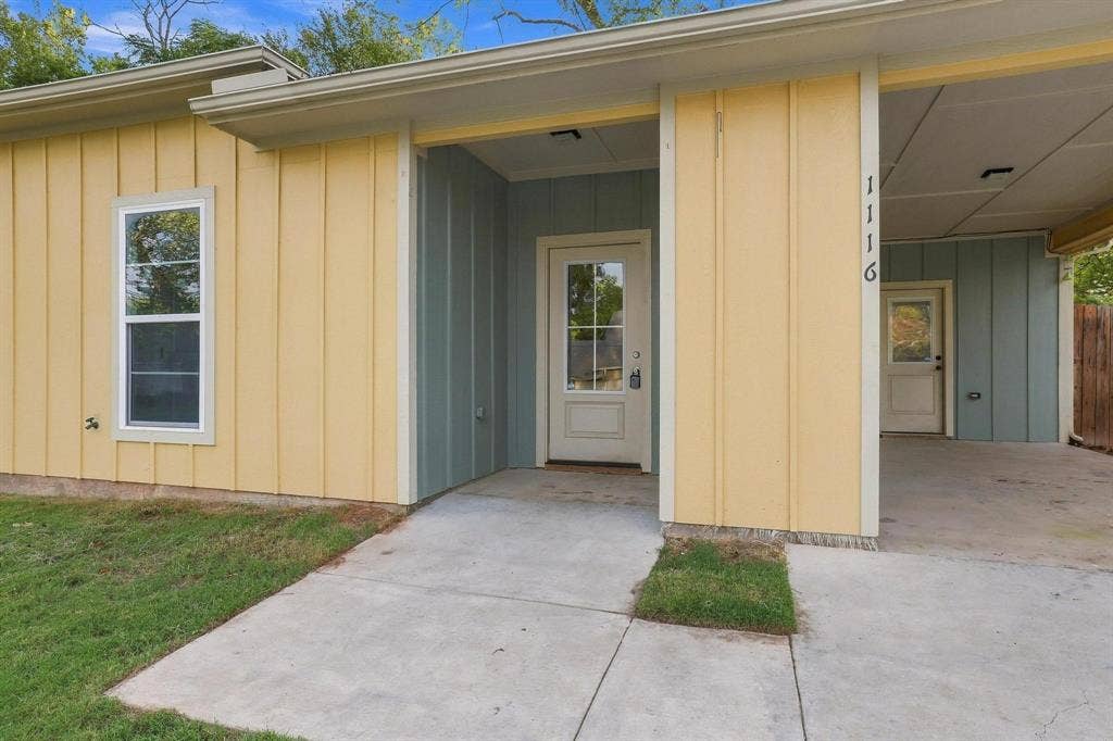 1116 S 6th Avenue, Denison, TX 75021 Board-and-batten exterior with contrasting siding colors, covered carport, and glass-paneled entry door