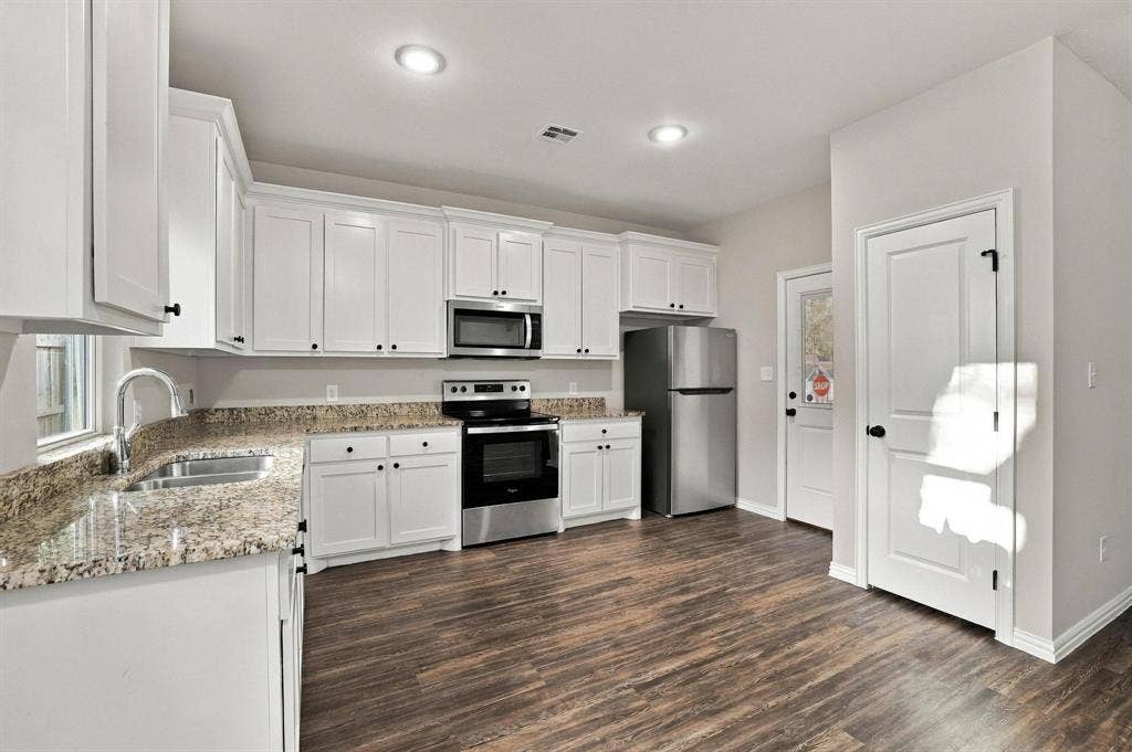 1116 S 6th Avenue, Denison, TX 75021 Kitchen featuring white cabinetry, stone-finish countertops, stainless steel appliances, recessed lighting, and wood-finish flooring