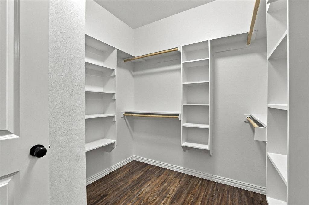 1116 S 6th Avenue, Denison, TX 75021 Walk-in closet featuring white built-in shelving, wooden garment rods, and dark wood-finish flooring