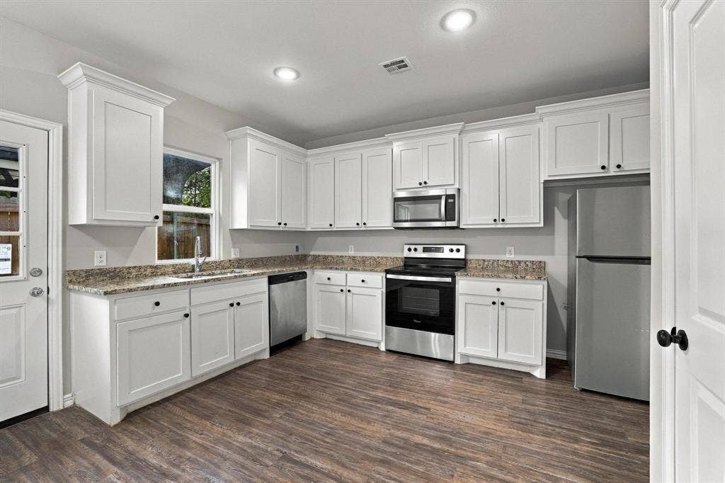 1116 S 6th Avenue, Denison, TX 75021 Kitchen featuring white cabinetry, stone-finish countertops, stainless steel appliances, recessed lighting, and wood-finish flooring