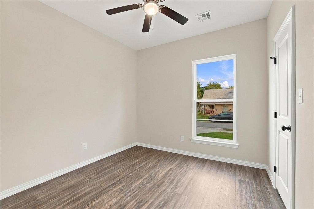 1116 S 6th Avenue, Denison, TX 75021 Neutral-toned interior room featuring wood-finish flooring, a ceiling fan with integrated lighting, and a single-hung window