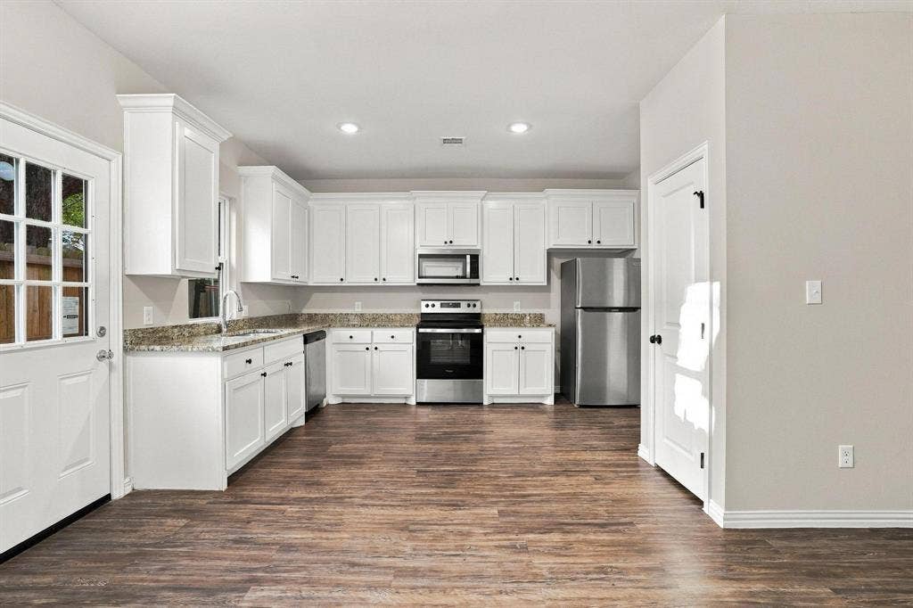 1116 S 6th Avenue, Denison, TX 75021 Kitchen featuring white cabinetry, stone-surface countertops, wood-finish flooring, recessed lighting, and stainless steel appliances