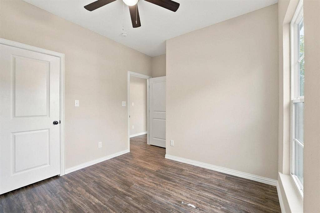 1116 S 6th Avenue, Denison, TX 75021 Interior space featuring wood-finish flooring, neutral wall paint, multi-panel interior doors, and a ceiling-mounted light fixture with a fan