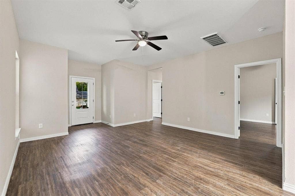 1116 S 6th Avenue, Denison, TX 75021 Open-concept area featuring wood-finish flooring, neutral wall paint, vaulted ceilings, and a ceiling fan with integrated lighting