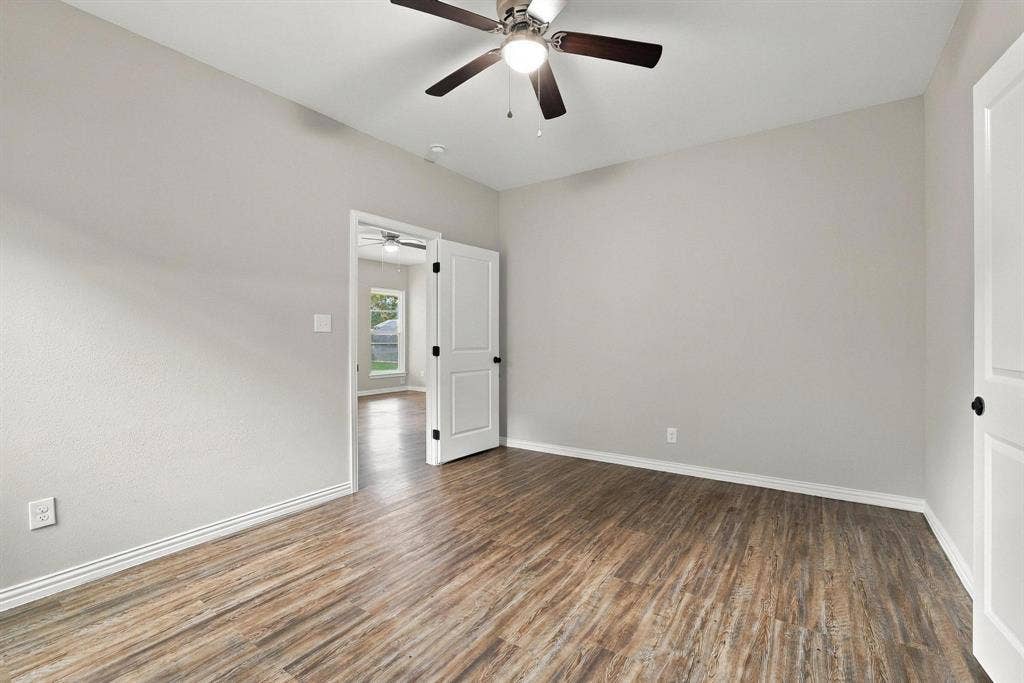 1116 S 6th Avenue, Denison, TX 75021 Neutral interior featuring wood-finish flooring, a ceiling fan with integrated lighting, and multi-panel doors