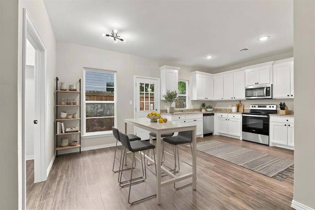 1116 S 6th Avenue, Denison, TX 75021 Kitchen featuring white cabinetry, wood-finish flooring, stainless steel appliances, quartz countertops, and recessed lighting