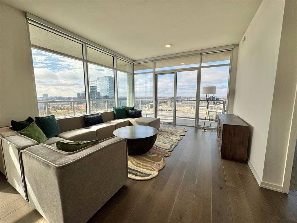 6911 Cowboys Way, #913, Frisco, TX 75034 Living room featuring hardwood / wood-style flooring and expansive windows