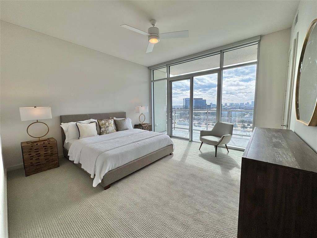 6911 Cowboys Way, #913, Frisco, TX 75034 Bedroom with expansive windows, light colored carpet, access to exterior, and ceiling fan
