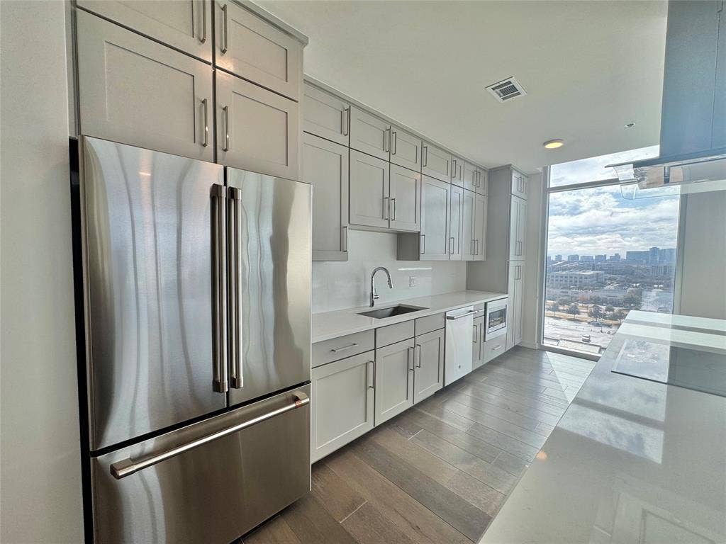 6911 Cowboys Way, #913, Frisco, TX 75034 Kitchen with light hardwood / wood-style flooring, sink, a wall of windows, and appliances with stainless steel finishes