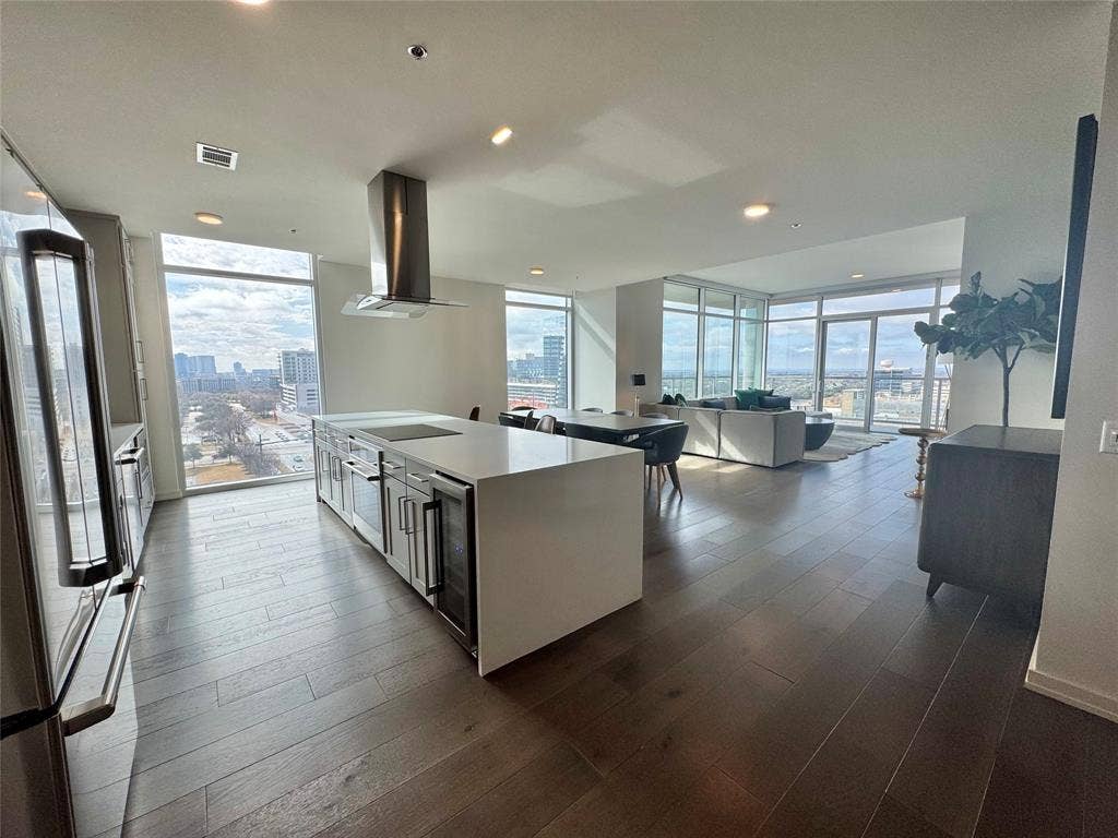 6911 Cowboys Way, #913, Frisco, TX 75034 Kitchen featuring expansive windows, island exhaust hood, a kitchen island with sink, and stainless steel appliances