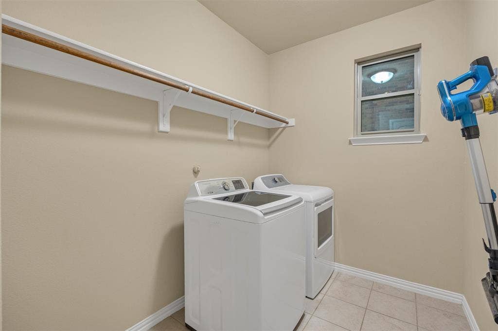3014 Aurora Mist Drive, Little Elm, TX 75068 Utility area featuring neutral tile flooring, built-in wall-mounted shelving with a clothes rod, and a single-pane window
