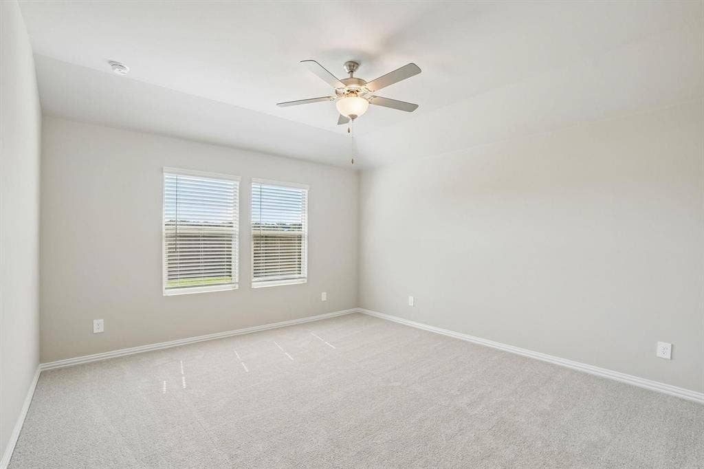 6110 CHICKNEY Drive, Princeton, TX 75071 Vaulted ceiling featuring a central brushed-nickel ceiling fan with integrated lighting, neutral wall paint, wall-to-wall carpeting, and double-paned windows with horizontal blinds