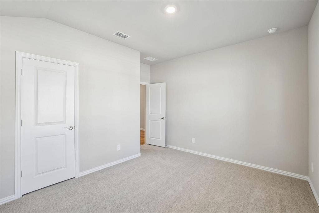 6110 CHICKNEY Drive, Princeton, TX 75071 Neutral-toned interior space featuring light-colored wall paint, plush carpeting, multi-panel doors with brushed-nickel hardware, and recessed lighting