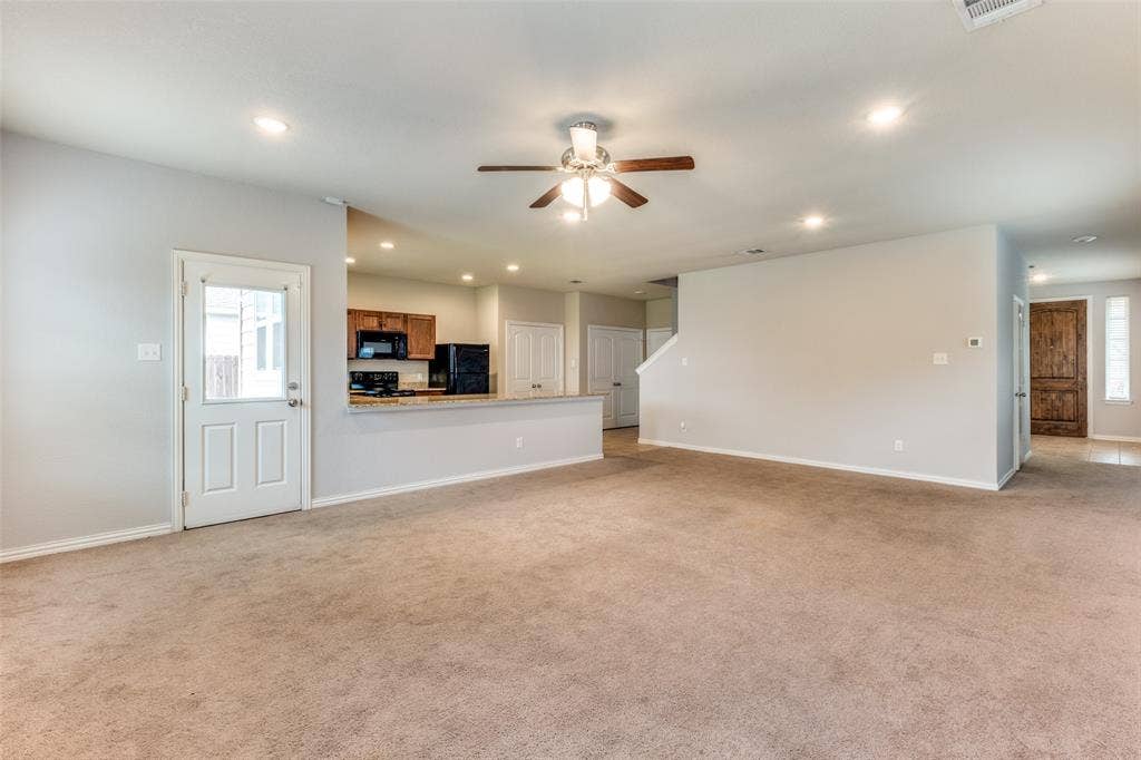 4662 Ralph Lane, Dallas, TX 75227 Open-concept interior featuring carpeting, a ceiling fan with integrated lighting, recessed lighting, a pass-through kitchen counter, and a single-light door