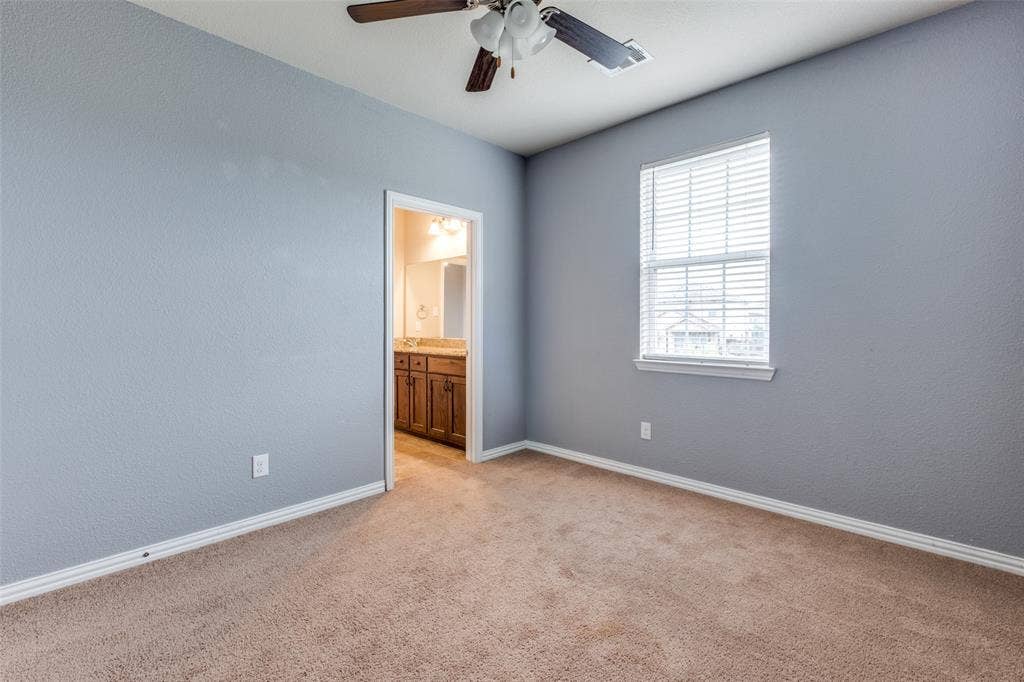 4662 Ralph Lane, Dallas, TX 75227 Neutral wall tones paired with neutral carpeting, single-hung window with adjustable blinds, and ceiling fan with integrated lighting