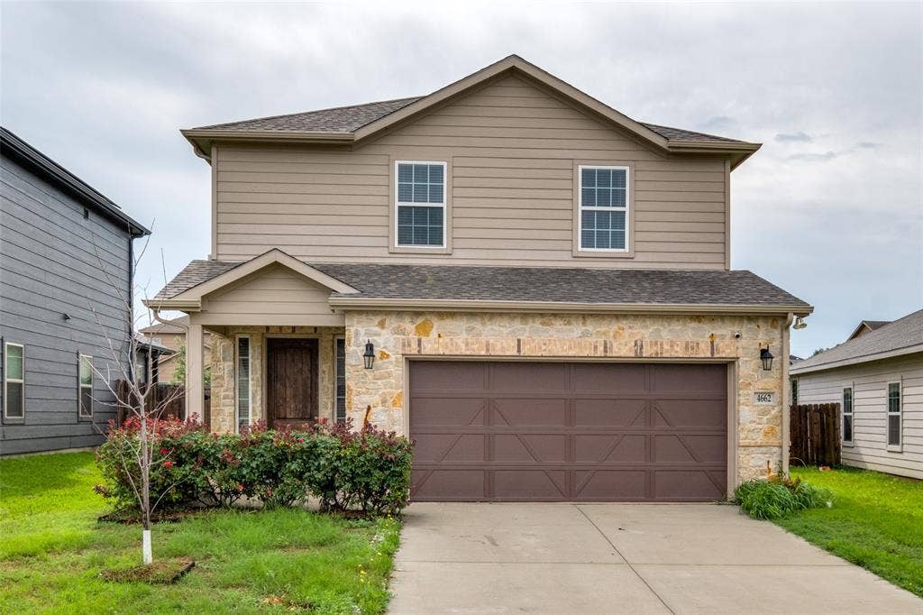 4662 Ralph Lane, Dallas, TX 75227 Two-story residence featuring a partial stone facade, horizontal siding, a covered entryway, and an attached two-car garage with cross-buck detailing