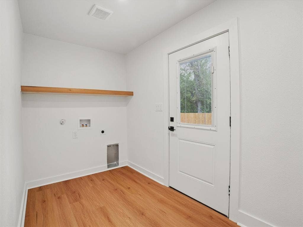 9059 Quinn Street, Dallas, TX 75217 Utility space featuring wood-finish flooring, a wall-mounted floating wood shelf, and an exterior door with an integrated window