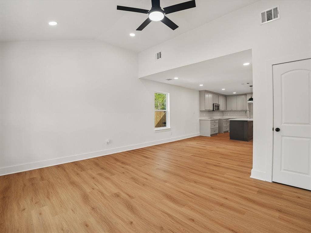 9059 Quinn Street, Dallas, TX 75217 Vaulted ceiling featuring a central matte black ceiling fan, wood-finish flooring, recessed lighting, and a neutral color palette