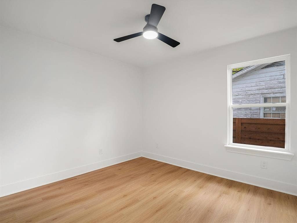 9059 Quinn Street, Dallas, TX 75217 Neutral interior featuring wood-finish flooring, a matte black ceiling fan with integrated lighting, and a single-hung window