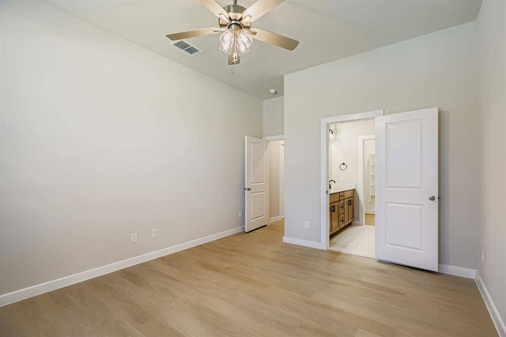 1204 Pebblebrook Drive, McKinney, TX 75071 Room featuring high ceilings, wood-finish flooring, a central multi-blade ceiling fan with integrated lighting, and white interior doors