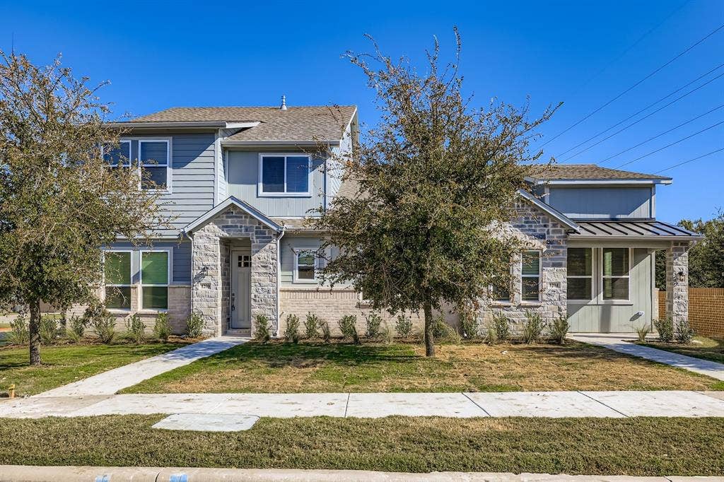1204 Pebblebrook Drive, McKinney, TX 75071 Two-story exterior featuring stone veneer accents, lap siding, a pitched roof, metal porch roofing, and a concrete walkway