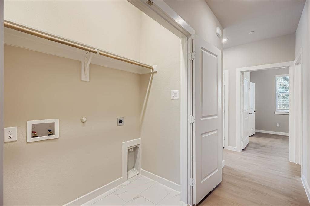 1204 Pebblebrook Drive, McKinney, TX 75071 Laundry area featuring recessed water supply connections, dedicated dryer venting, overhead shelving with a hanging rod, and light-toned tile flooring